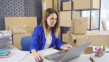 Business-woman-working-on-computer-and-tracking-orders-in-packing-and-cargo-warehouse.
